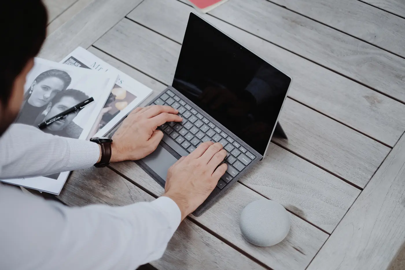 Profissional trabalhando em um notebook ao lado de um assistente inteligente